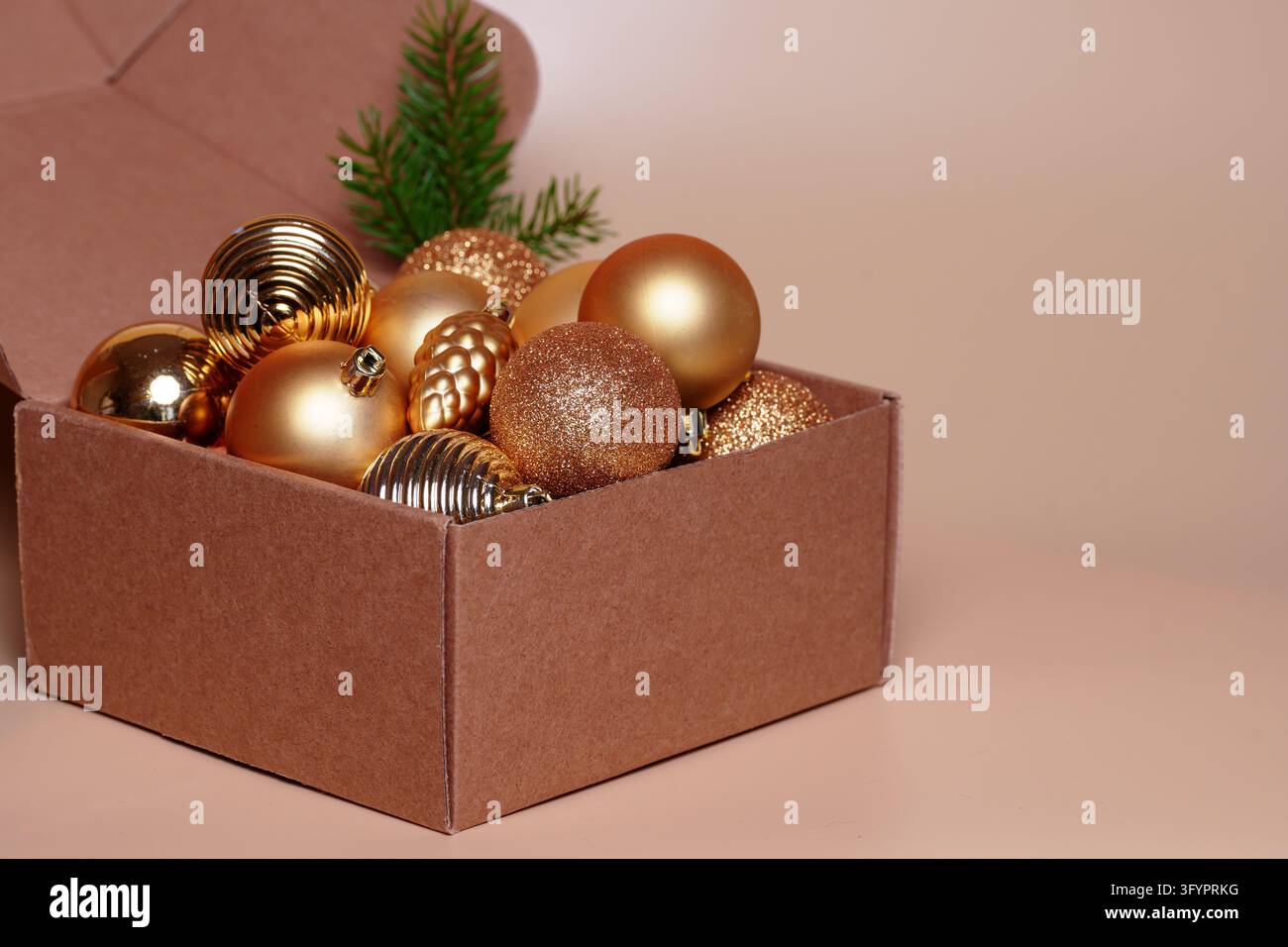 Scatola di cartone piena di ornamenti. Preparazione di imballaggi regalo ecologici per Natale, consegna logistica al dettaglio, spazio per il testo Foto Stock