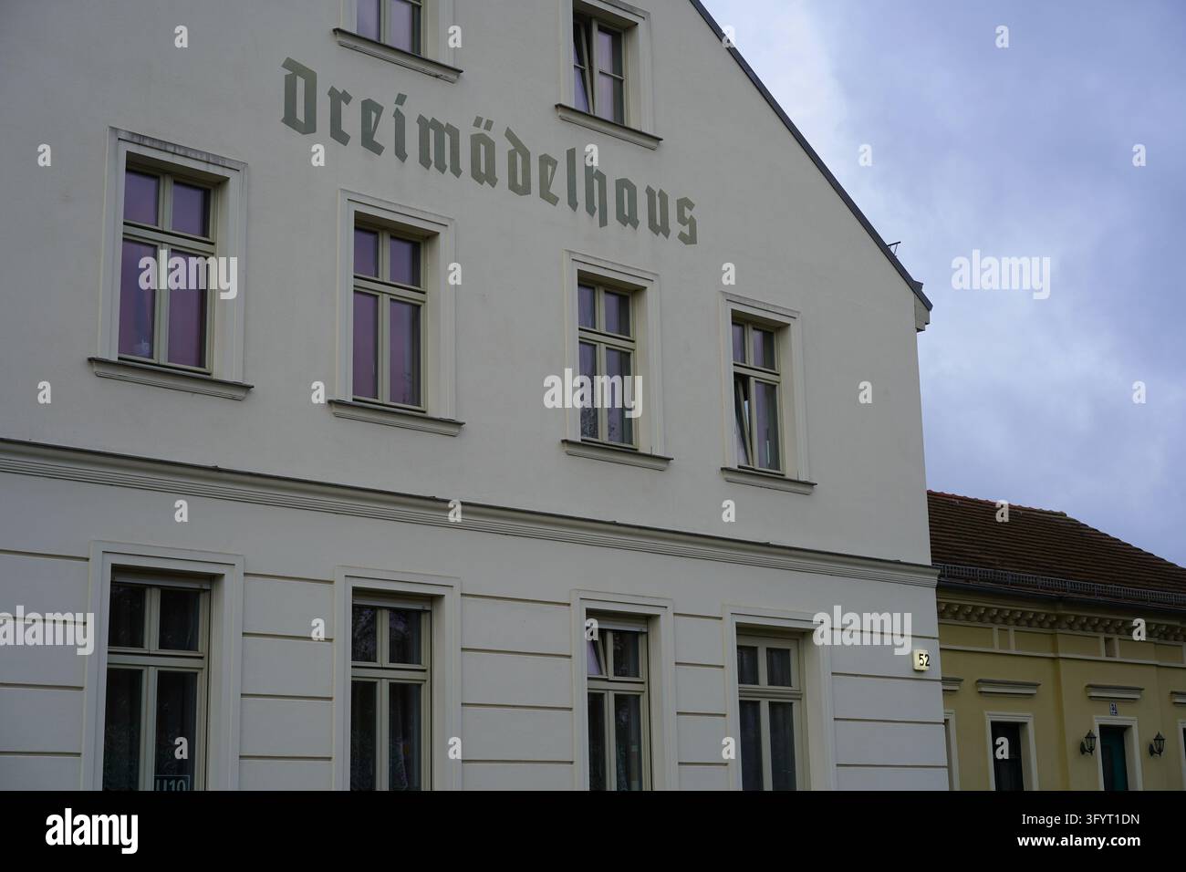 Berlino, Germania - 28 ottobre 2026: Edificio Dreimädelhaus ricostruito nel centro storico del villaggio di Alt-Karow, con lettere Fraktur tedesche. Foto Stock