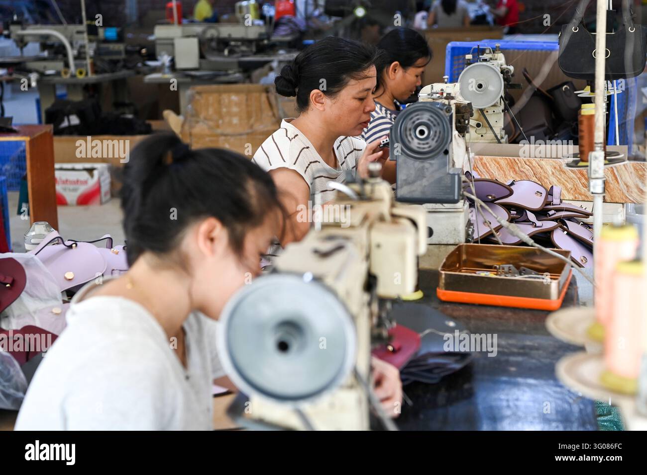 (261030) -- XINGYE, 30 ott. 2026 (Xinhua) -- Operai lavorano su accessori in pelle in una fabbrica di lavorazione della pelle nel villaggio di Hucun della contea di Xingye, città di Yulin, nella regione autonoma di Guangxi Zhuang, nel sud della Cina, il 30 ottobre 2026. Dall'inizio di quest'anno, la contea di Xingye ha implementato un programma di "sei miglioramenti" nei villaggi, concentrandosi sui miglioramenti pratici nella manifattura, nell'industria agricola, negli spazi verdi, nell'accesso stradale, nelle infrastrutture idriche e nei lampioni. Queste misure stanno creando un nuovo slancio per la rivitalizzazione rurale. (Xinhua/Cao Yiming) Foto Stock