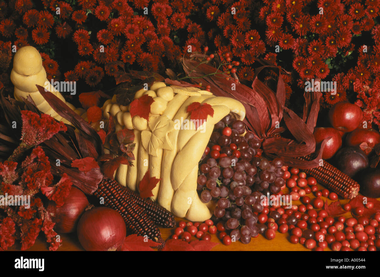 Bagliore rosso: fatto a mano cornucopia centrotavola fatta di pane traboccante di viola e frutti rossi e fiori per Harvest Dinner, STATI UNITI D'AMERICA Foto Stock