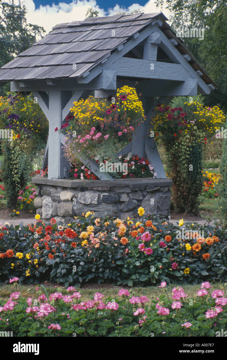 Wishing Well circondato da fiori nel giardino pubblico, Point Defiance Park, Tacoma, Stati Uniti di Washington Foto Stock