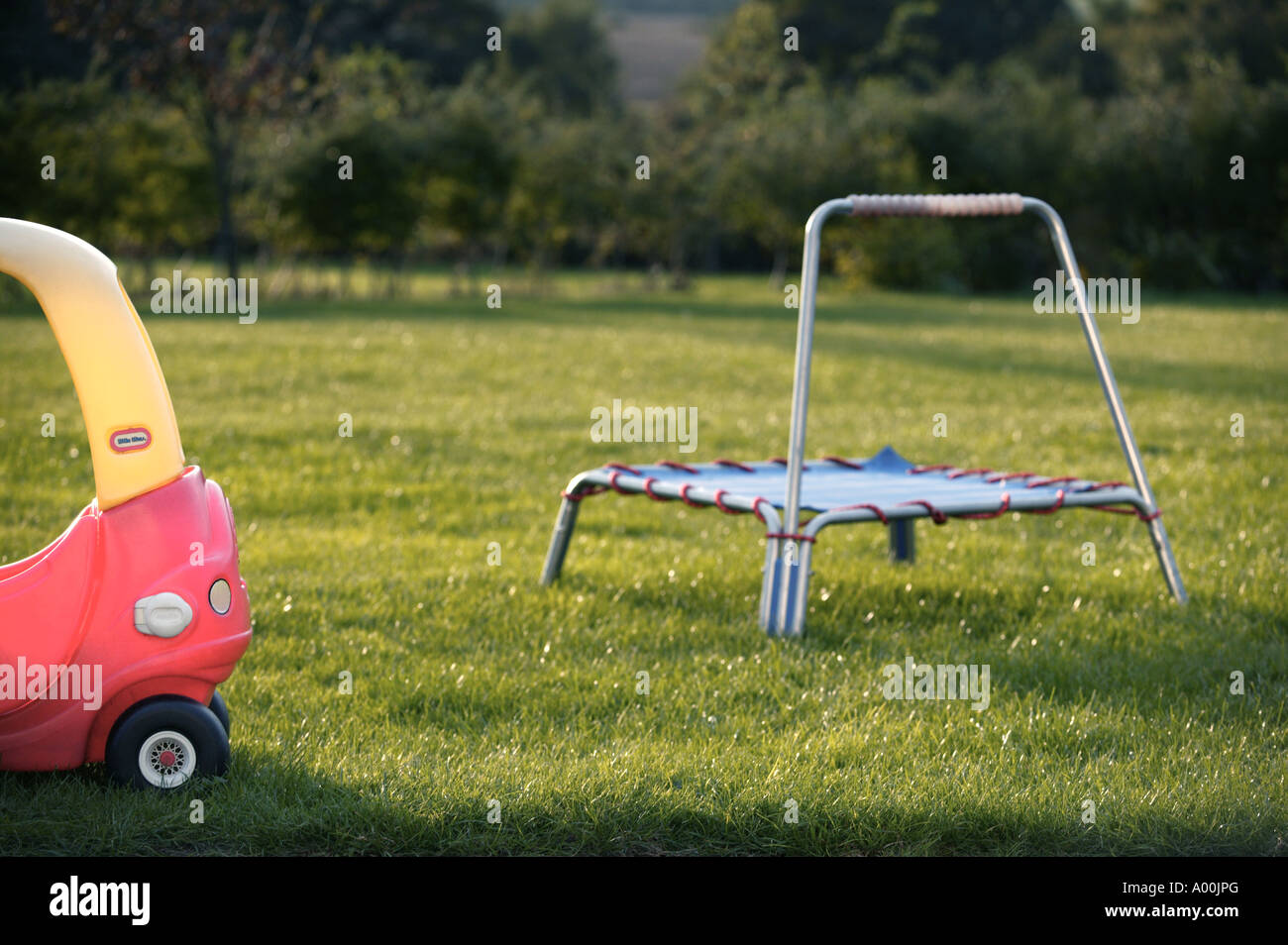 Gioco del bambino concetti a casa in giardino con trampolino e red giocattolo auto Foto Stock