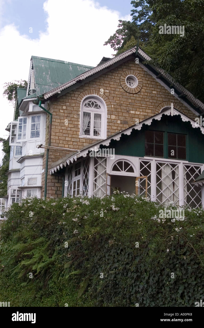 Splendida casa storica dell'epoca britannica a Darjeeling, Bengala Occidentale, India, caratterizzata da architettura coloniale, pareti in pietra, e tetti verdi a tetto spiovente. Foto Stock