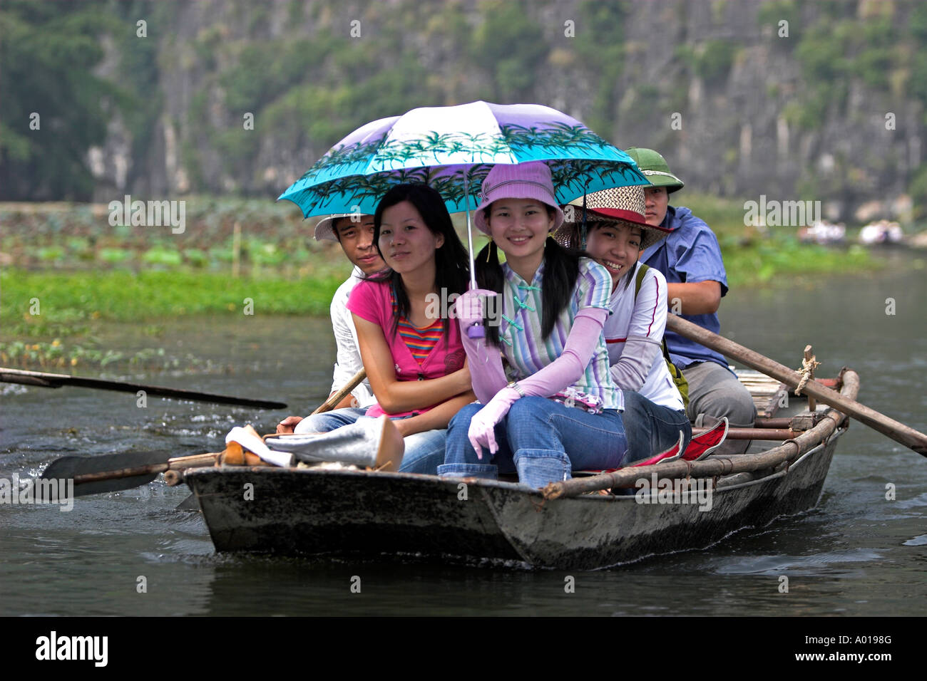 Tre ragazze in barca visita Tam Coc grotte Ngo Dong fiume vicino a Ninh Binh Vietnam del nord Foto Stock