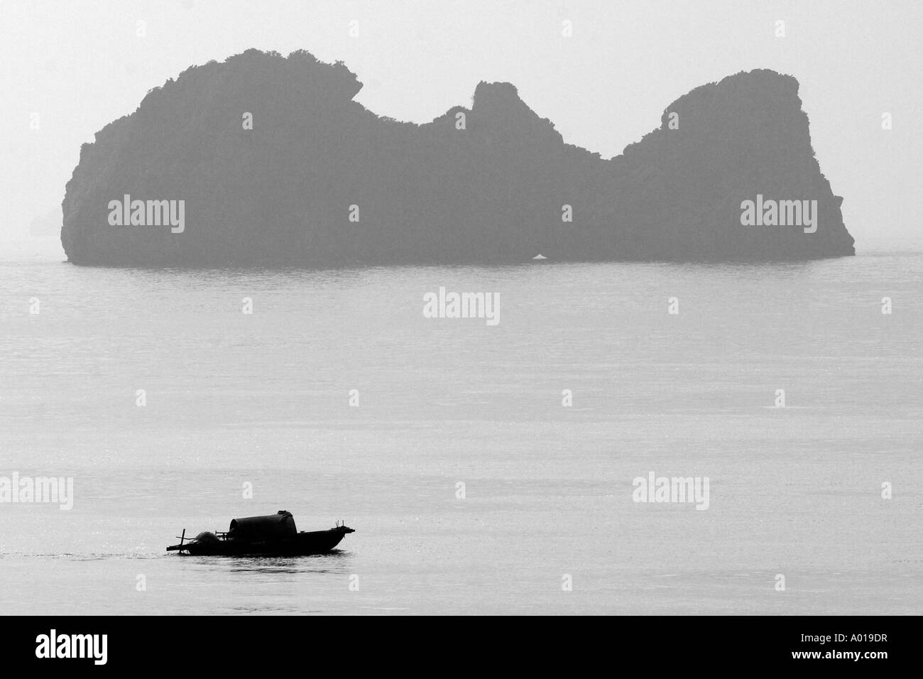 Silhouette tradizionale vietnamita passa in barca isola carsica off Cat Ba isola a nord est del Vietnam Foto Stock