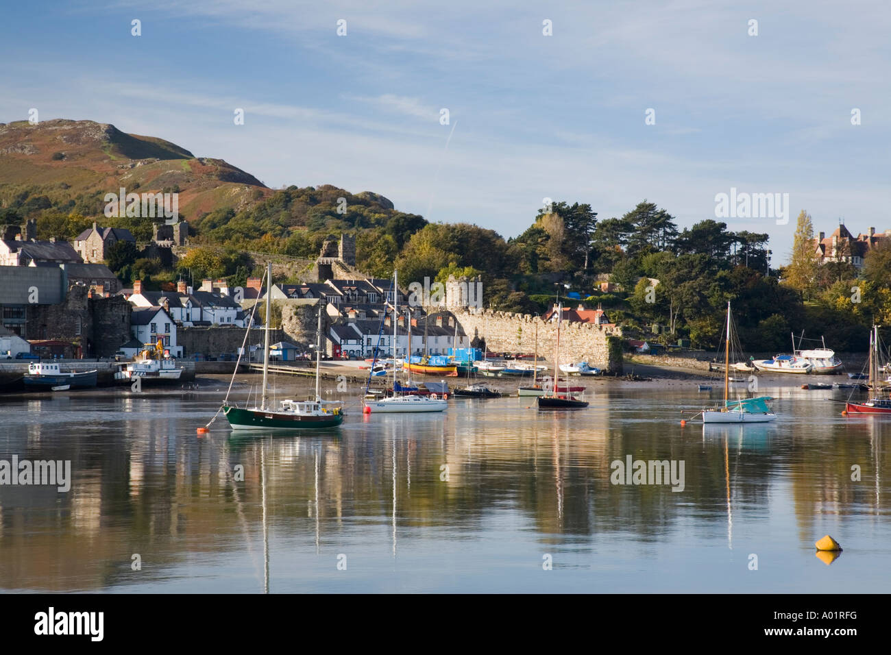 Vista su tutta Afon Conwy estuario del fiume di mura e la banchina di fronte del porto con barche ormeggiate. Conwy, Conwy county, il Galles del Nord, Regno Unito Foto Stock