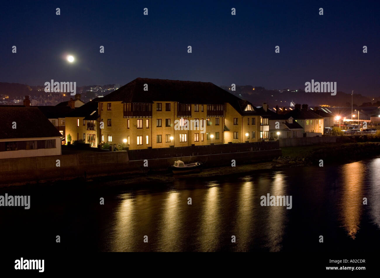 Blocco di appartamenti e di alloggi protetti dal fiume Rheidol Aberystwyth notturne con esposizione lunga Foto Stock