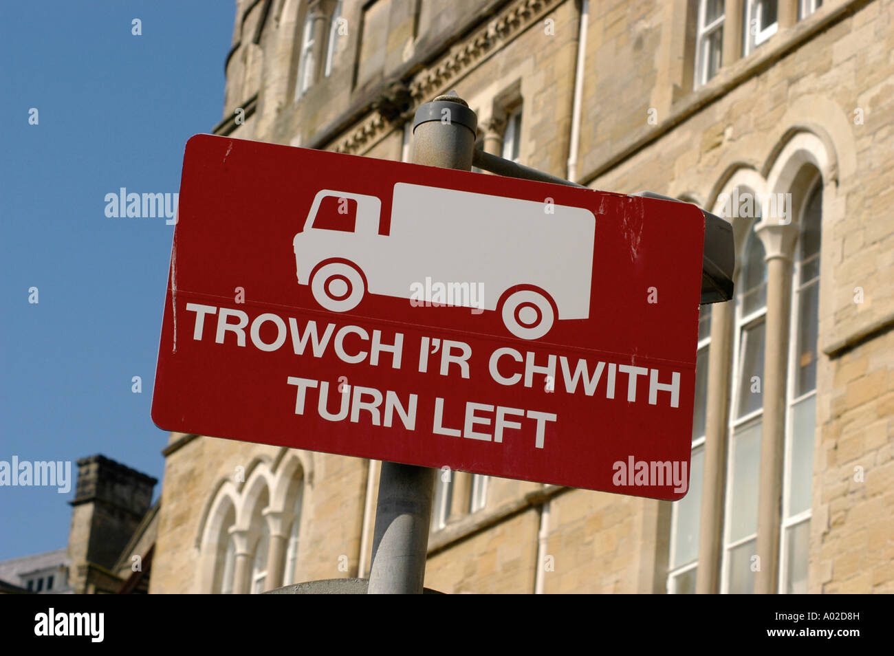 Aberystwyth bilingue inglese gallese girare a sinistra in strada segno [Trowch i'r Chwith] con icona del carrello, Wales UK Foto Stock