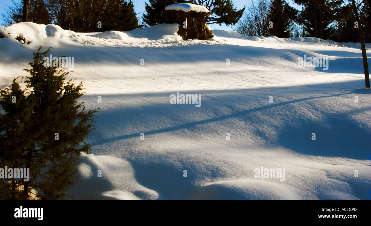 Panorama piccola casa del cacciatore con la neve e le ombre del tramonto Foto Stock