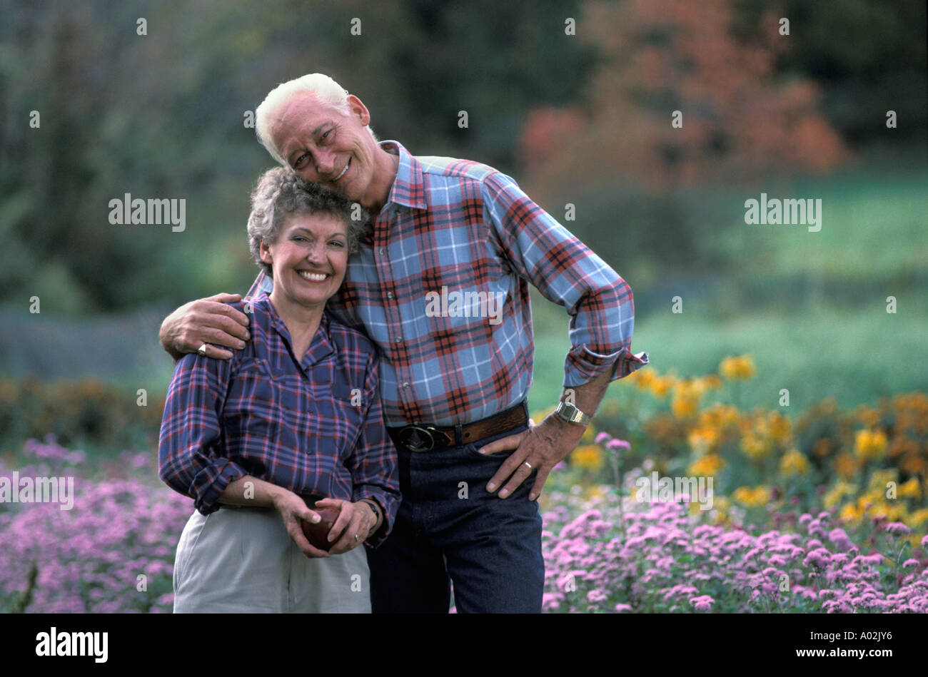 Felice coppia in pensione nel loro cortile anteriore Foto Stock