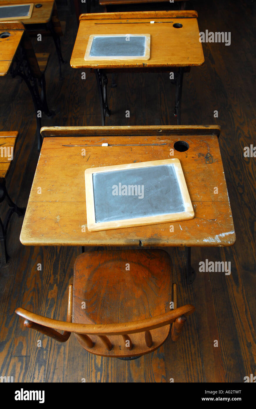 Sedie e scrivanie con lavagne in una vecchia del XIX secolo una stanza schoolhouse Foto Stock