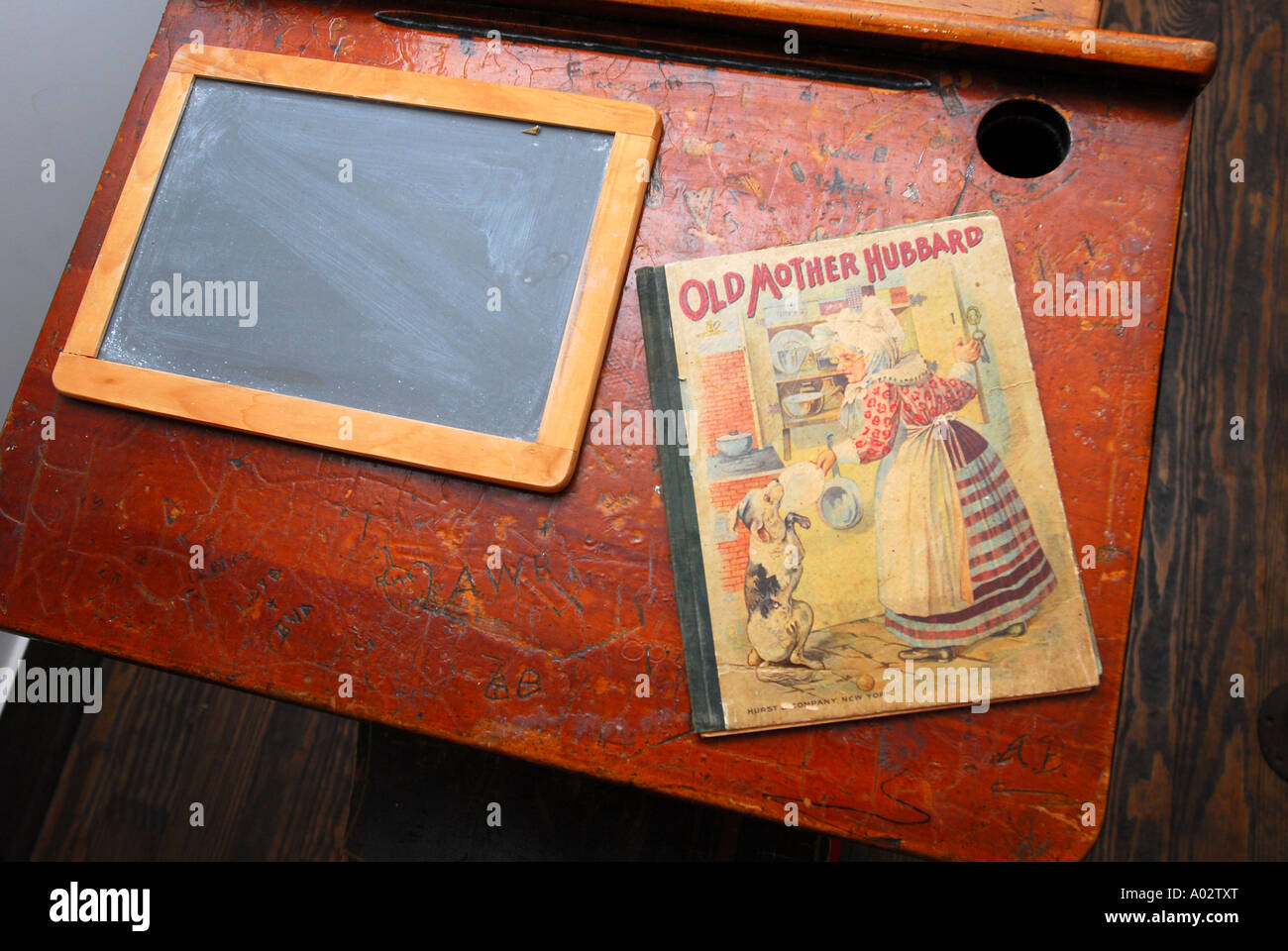 Il vecchio banco di scuola del XIX secolo in una sala school house con la vecchia madre Hubbard bambini s book e chalk board Foto Stock