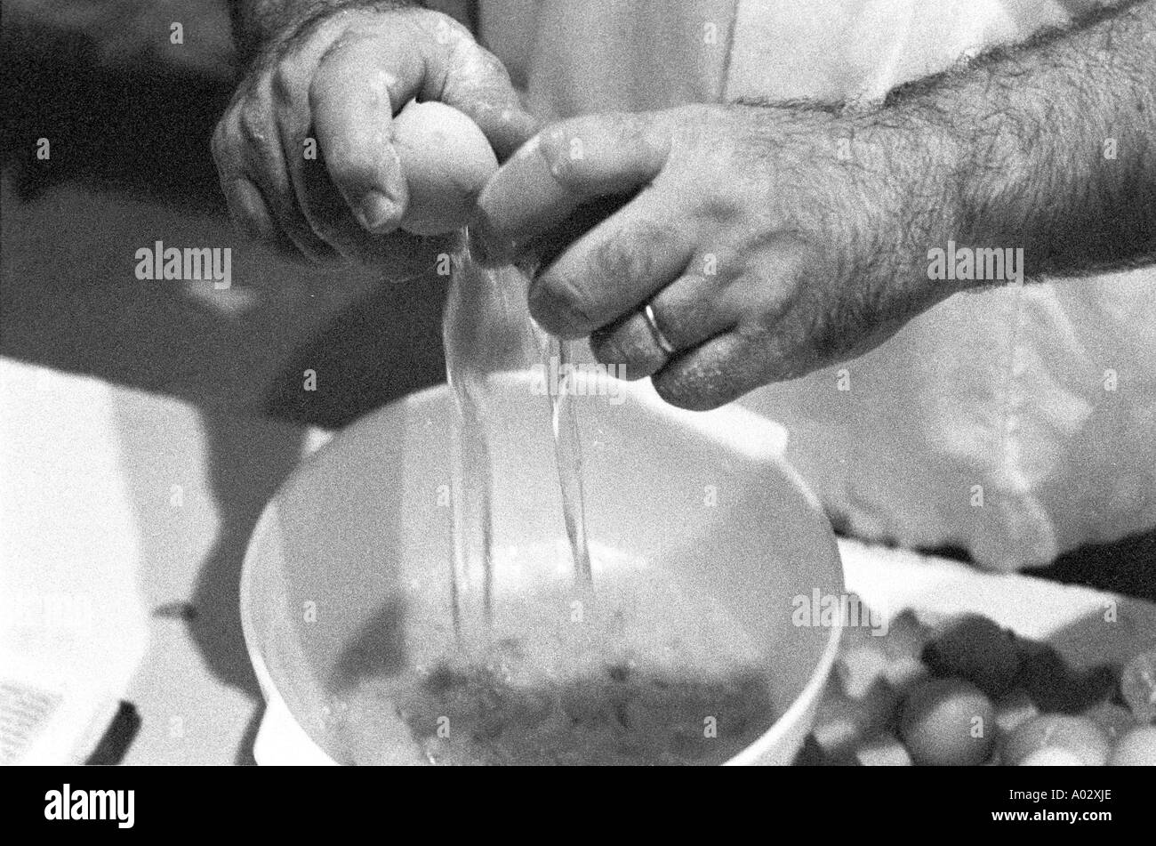 Francia baker s mani rompere le uova in una panetteria francese Foto Stock