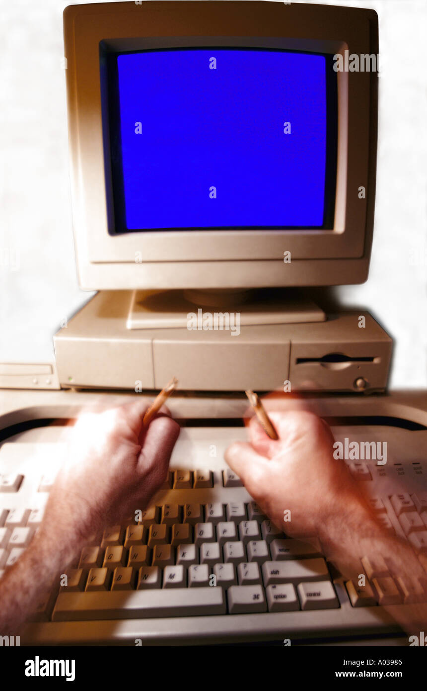 Le mani la rottura di una matita in senso di frustrazione di fronte a un computer Foto Stock