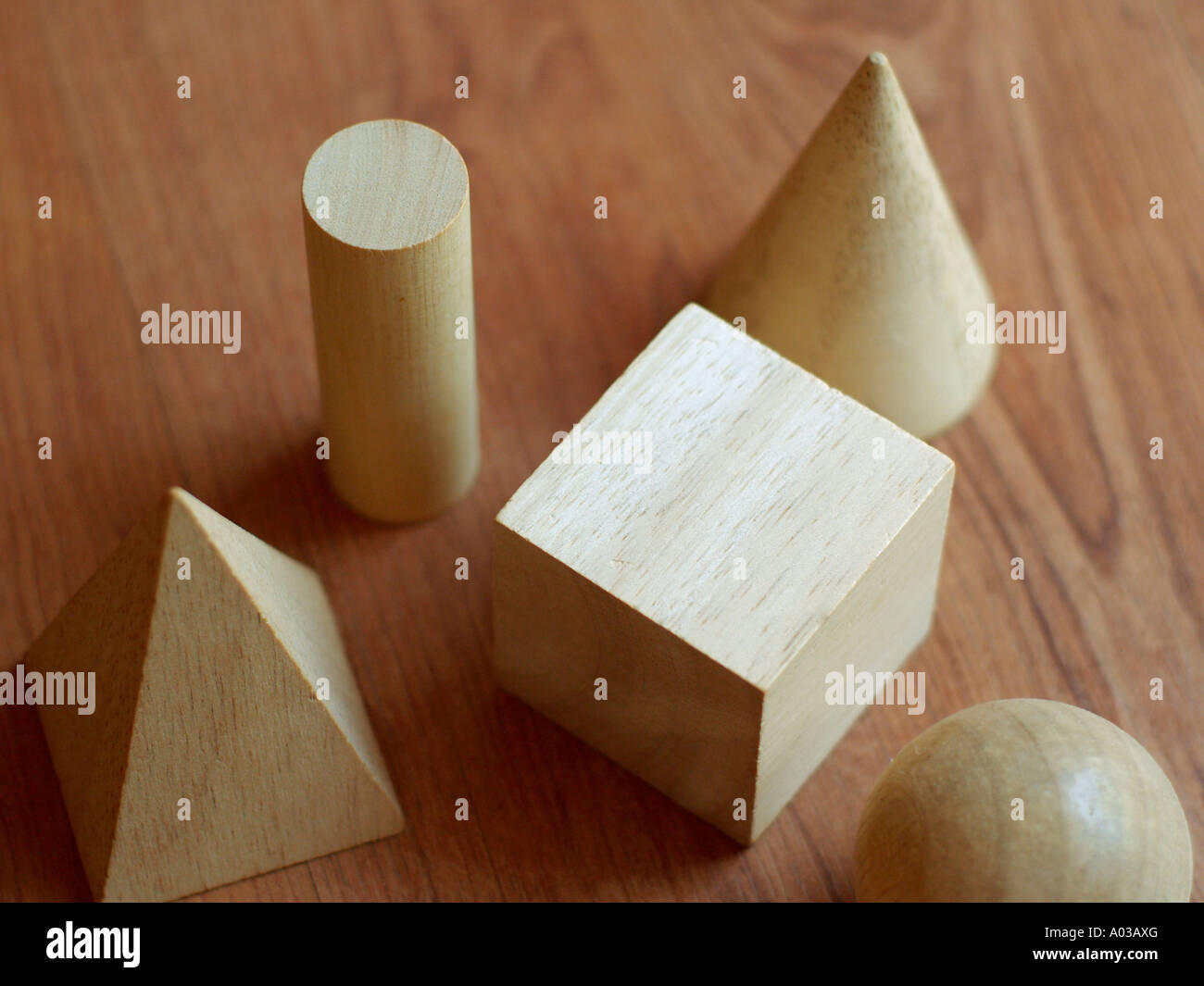Blocchi di legno in varie forme geometriche su una superficie di legno. Foto Stock