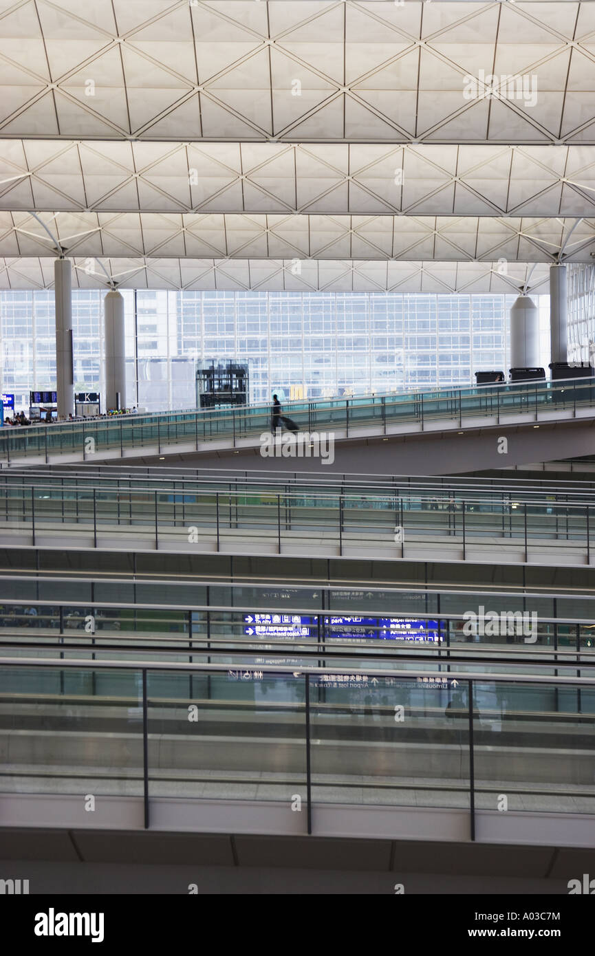 Solitario a piedi passeggero rampa di discesa in Hong Kong International Airport Foto Stock