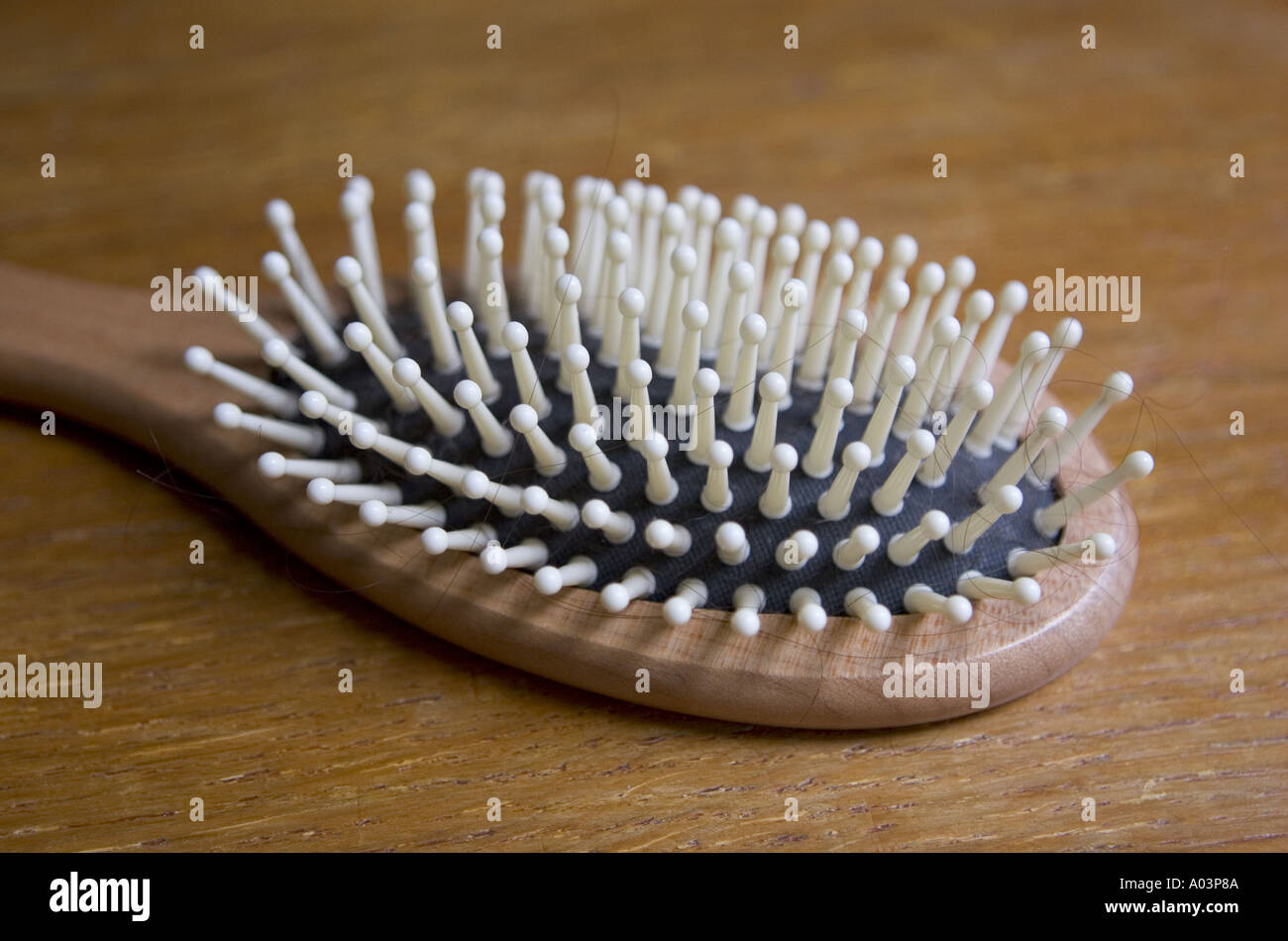 In prossimità di una spazzola con setole in plastica con peli neri su una superficie in legno Foto Stock