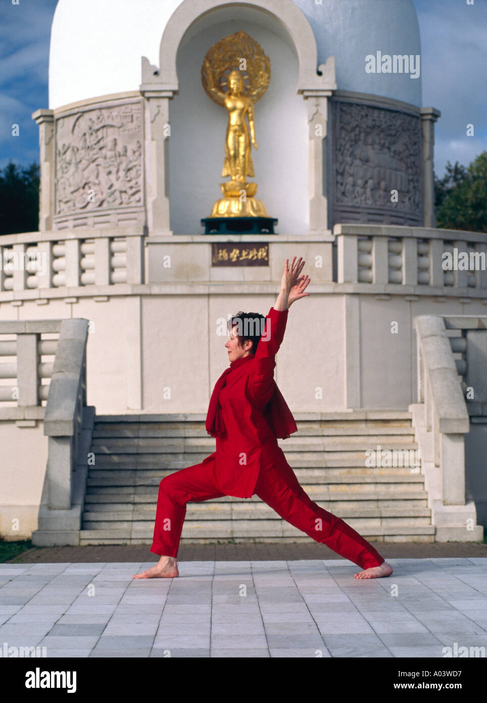 Credito foto DOUG BLANE Carol Smith insegnante di Yoga facendo guerriero Virabhadrasana pongono di fronte al Milton Keynes Peac buddista Foto Stock