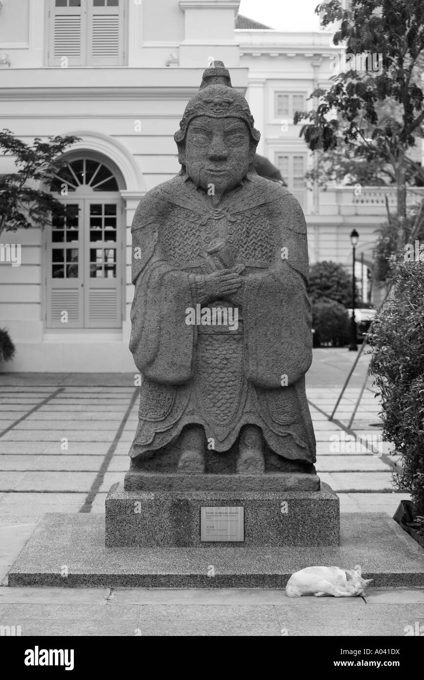 Asia Singapore gatto dorme sotto la figura del Generale Militare statua dalla dinastia Ming periodo al di fuori di civiltà asiatiche Museum Foto Stock