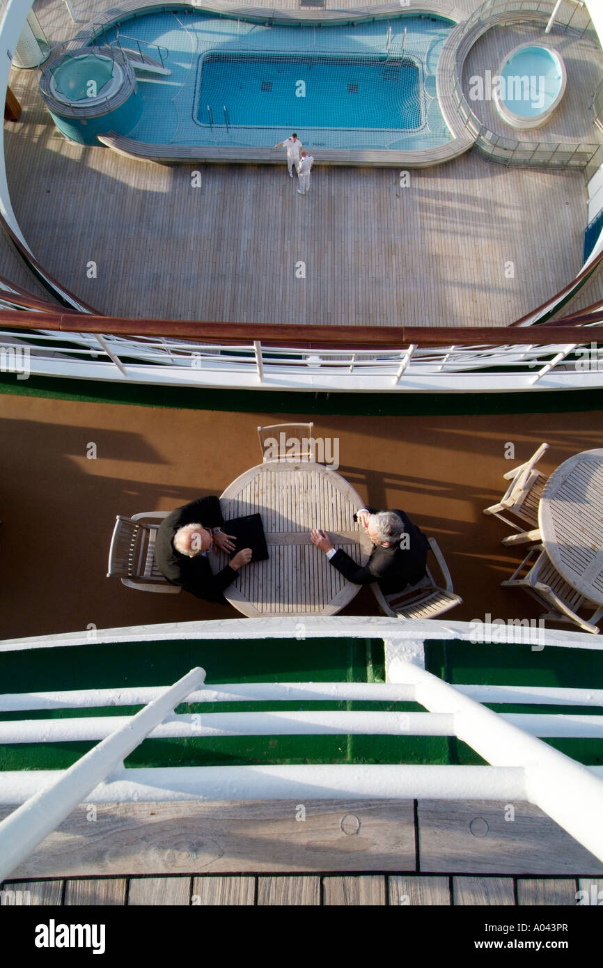 La vista dal ponte posteriore di una nave da crociera con le persone al tavolo parlando Foto Stock