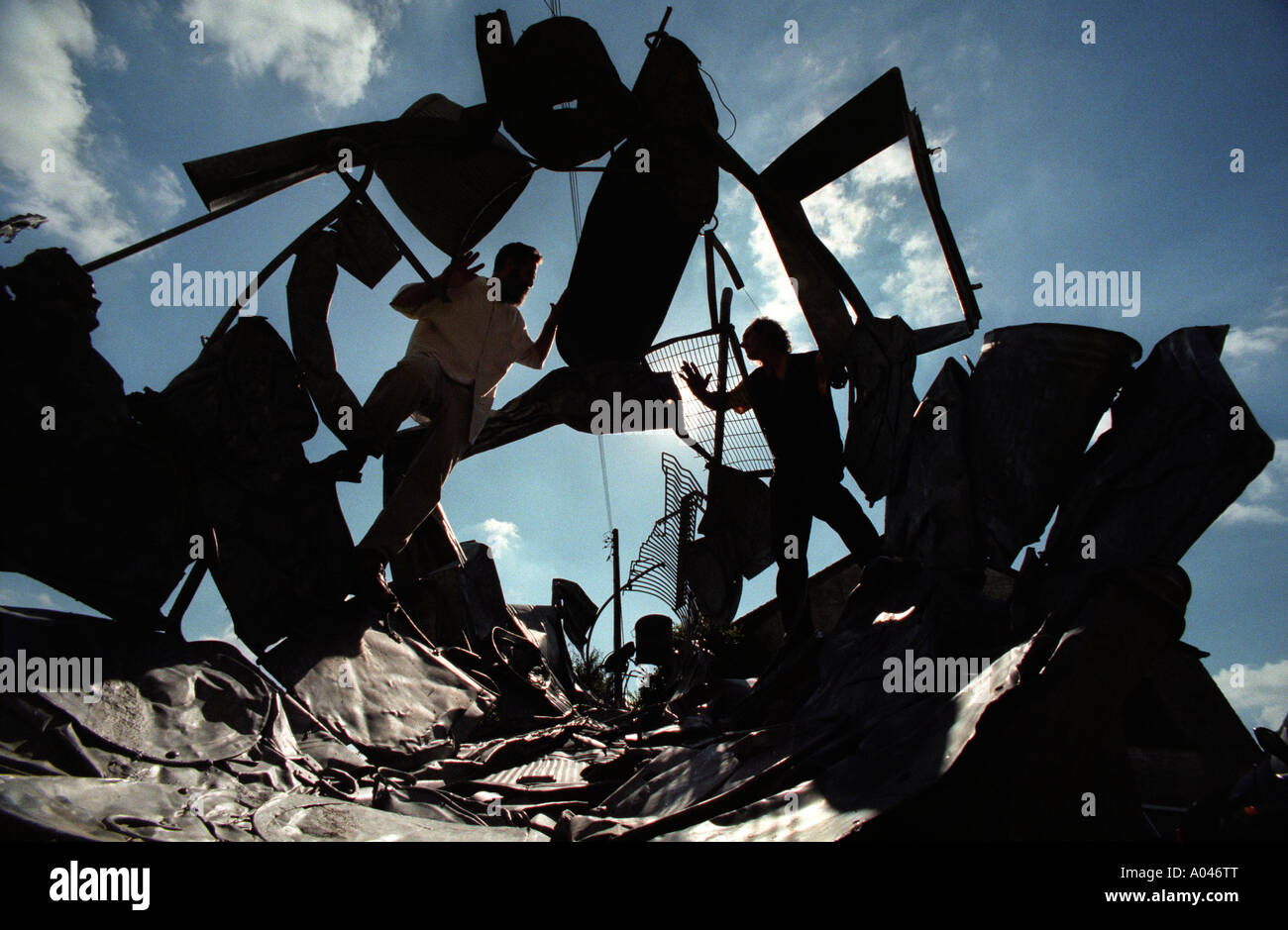 Due uomini creativi facendo una scultura fuori zincato di rottami di metallo Foto Stock
