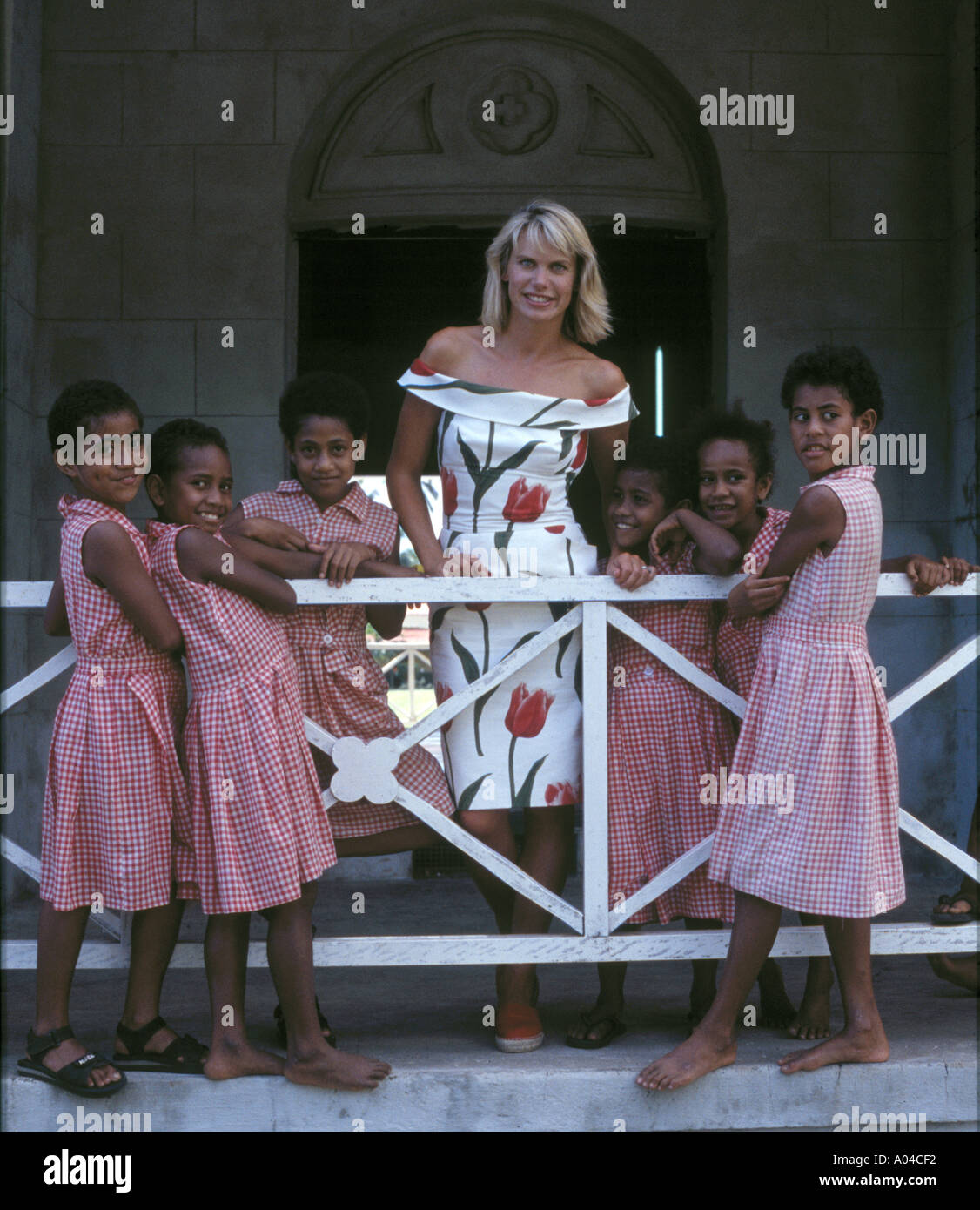 Il presentatore TV Anna Walker nelle isole Figi con studentesse in uniforme. Foto Stock