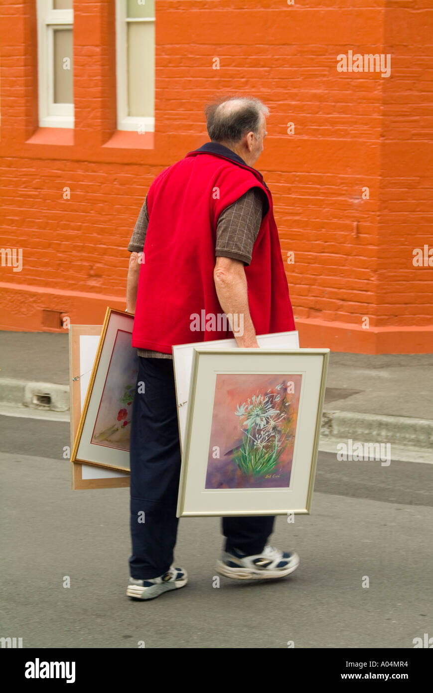 L'uomo offrendo dipinti per la vendita a livello comunitario mostra d'arte Hobart Tasmania Foto Stock