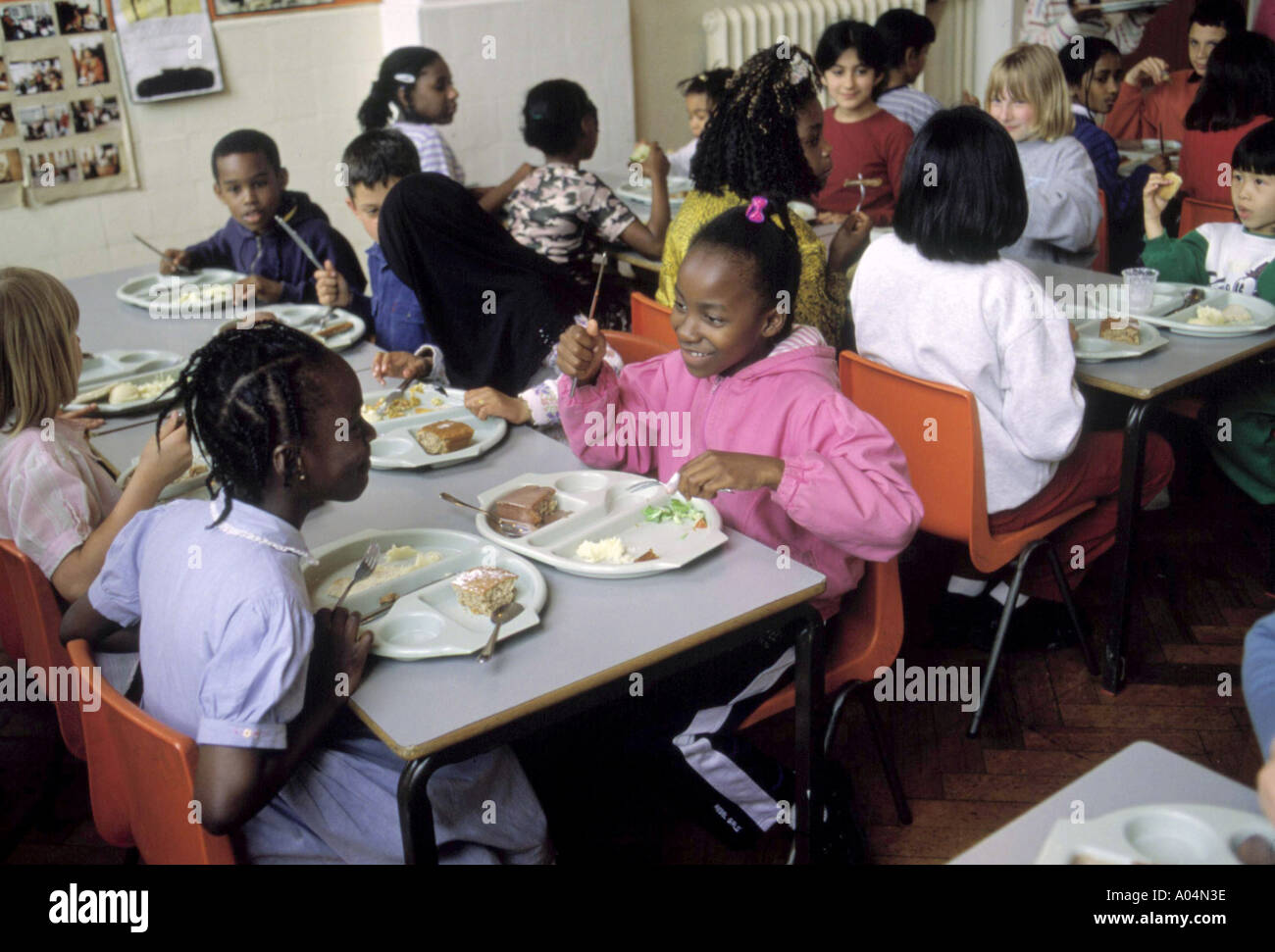 La scuola primaria mensa con i bambini a mangiare il pranzo Foto Stock