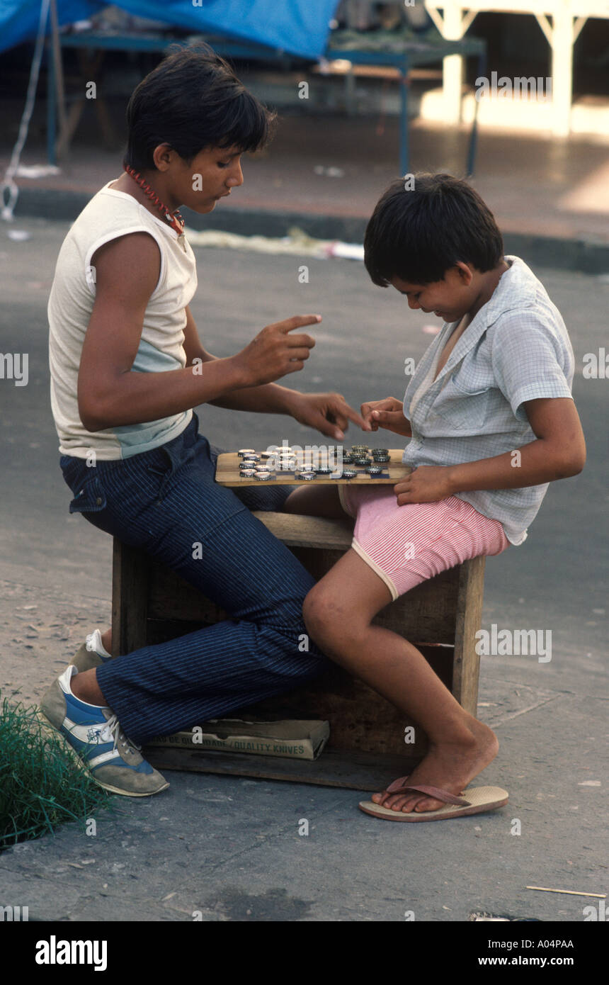 Due ragazzi giocare gioco da tavolo utilizzando bottiglie Top Quayside  Manaus il fiume Amazon Brasile anni 80 OMERO SYKES Foto stock - Alamy