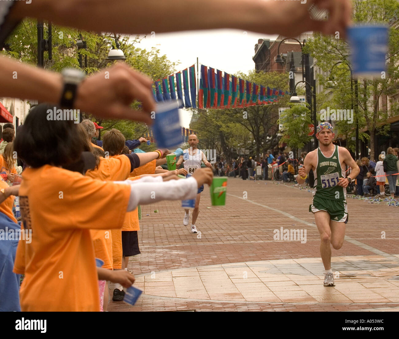 Come sostenitori tenere acqua, le guide passano nel Vermont City Marathon in Burlington, Vermont. Foto Stock