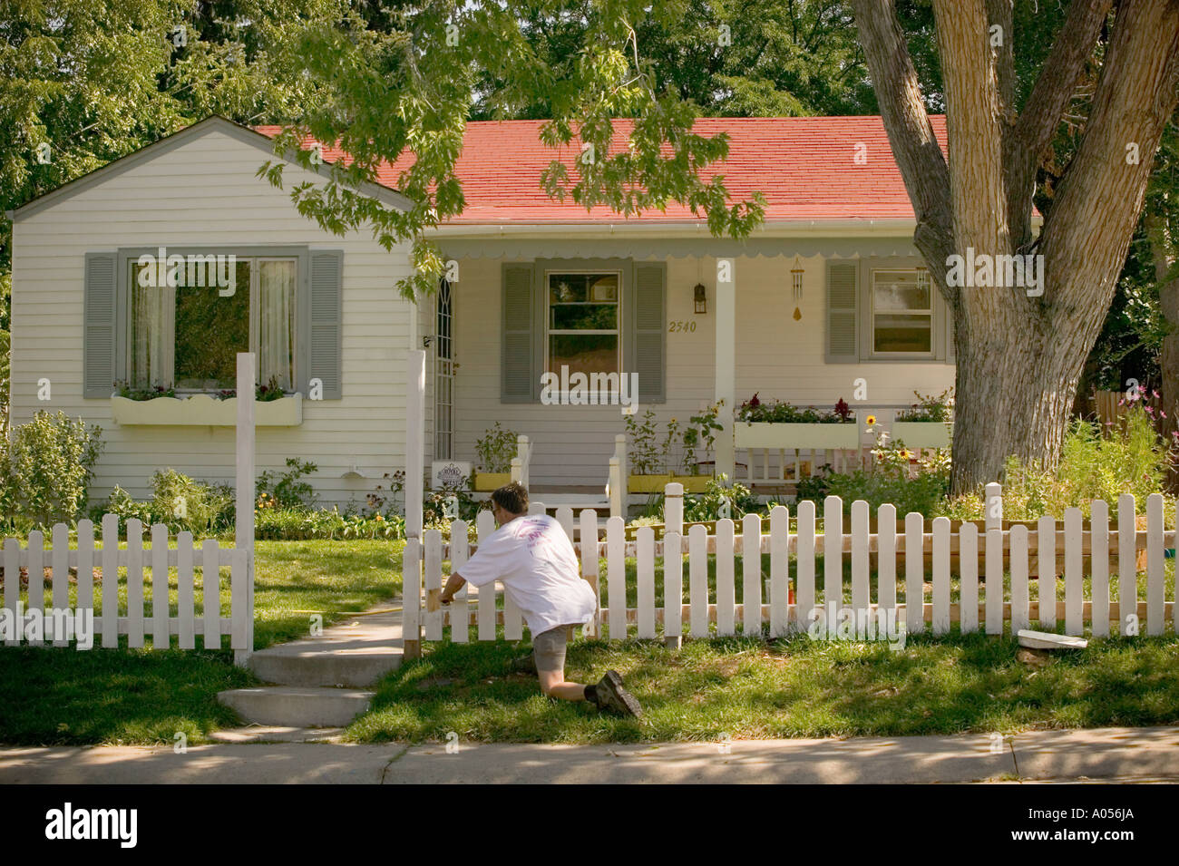 L'uomo bianco pittura Picket Fence davanti la casa Foto stock - Alamy