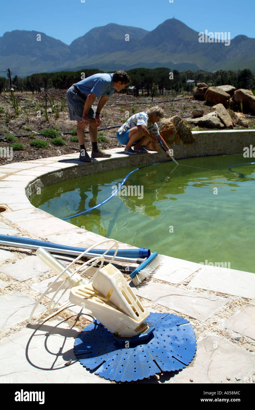 Giovane con la pulizia e controllo piscina Foto Stock