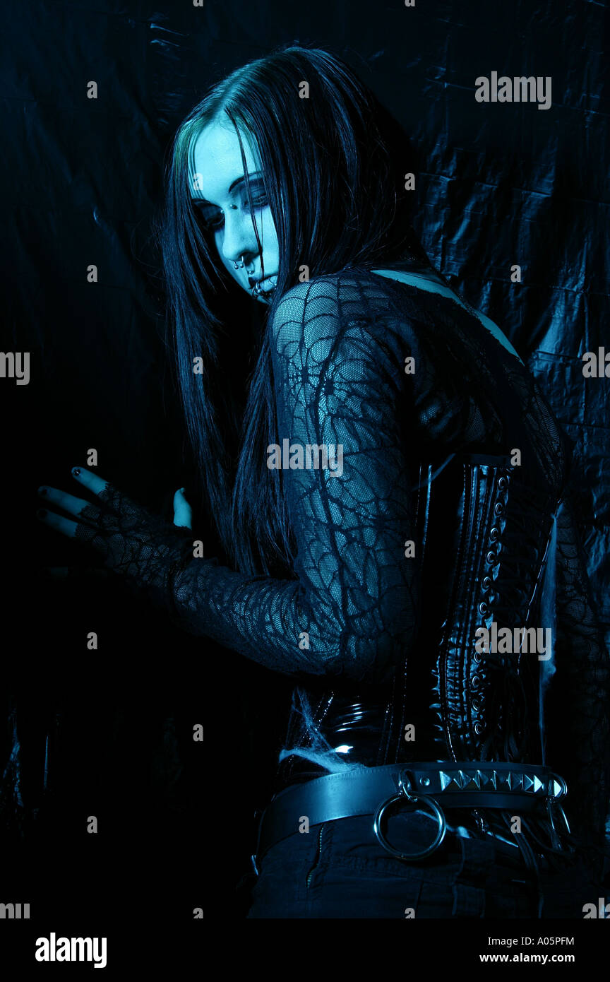 La donna gotica in posa alternativa di moda abbigliamento contro uno sfondo scuro e illuminazione drammatica. Foto Stock