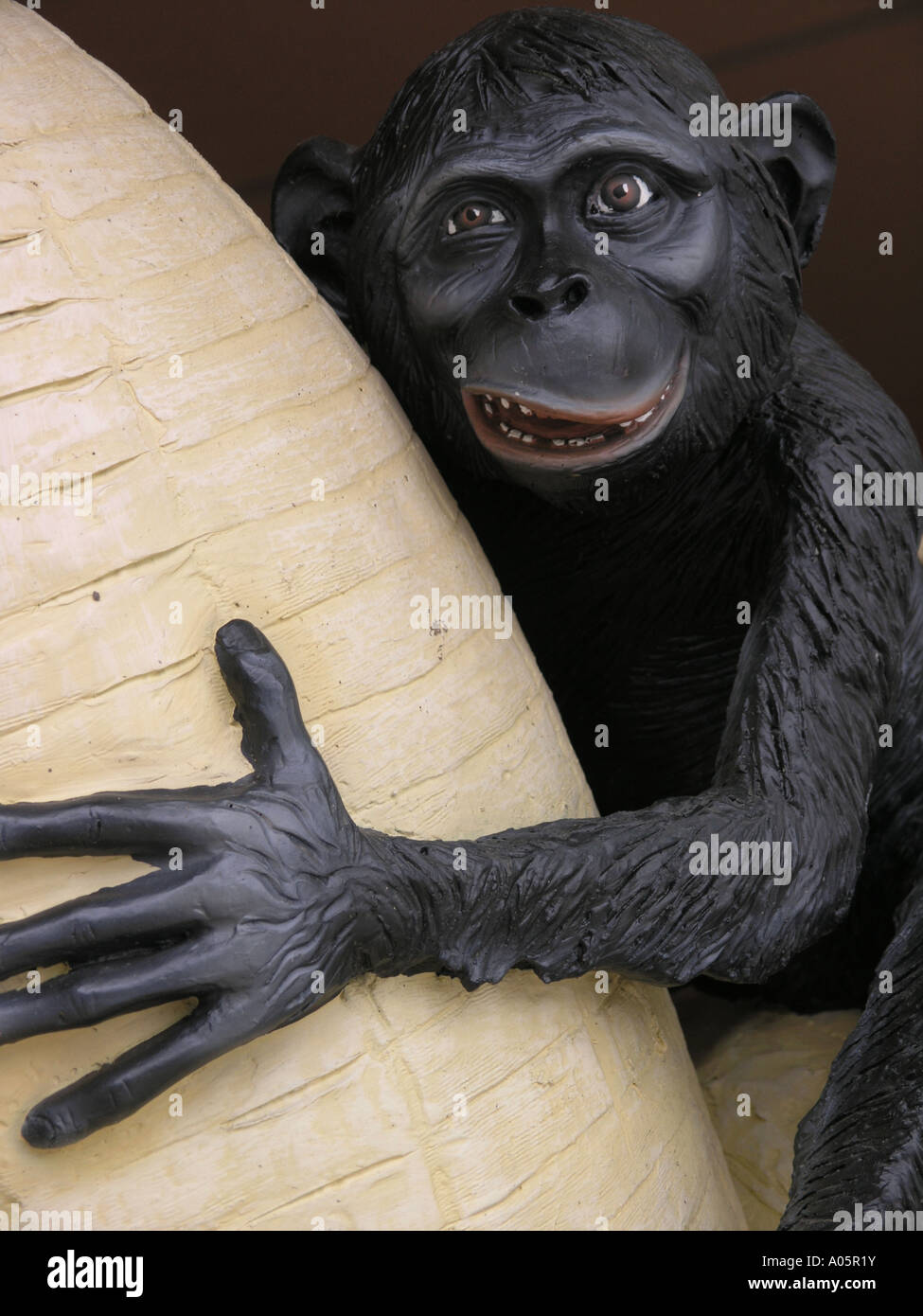 Chimpanze statua su una banana gigante Foto Stock