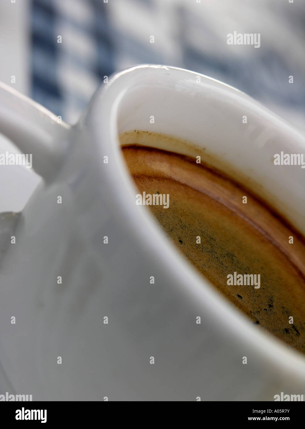 Nero caffè in una tazza bianca con piattino su un blu e bianche tovaglie Foto Stock