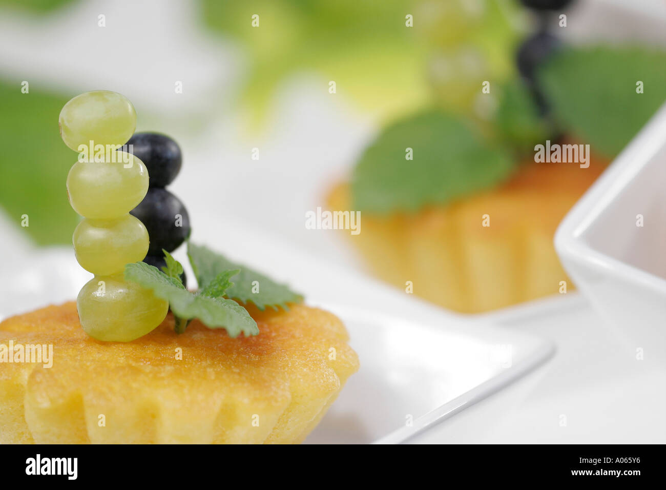 Pezzo di torta è guarnito con uva e foglie Foto Stock