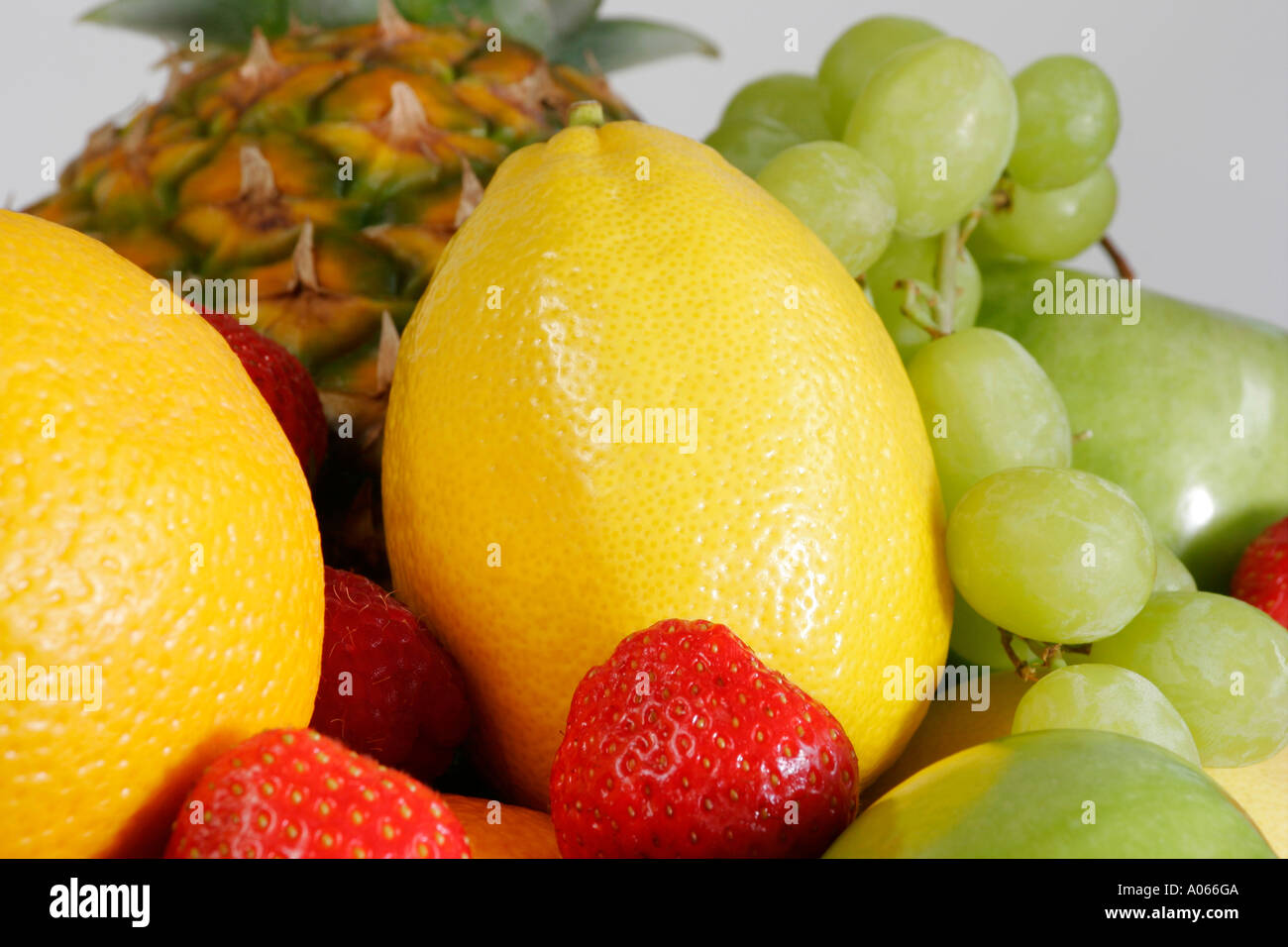 Una varietà di limone fragole mele uva e ananas visto insieme Foto Stock