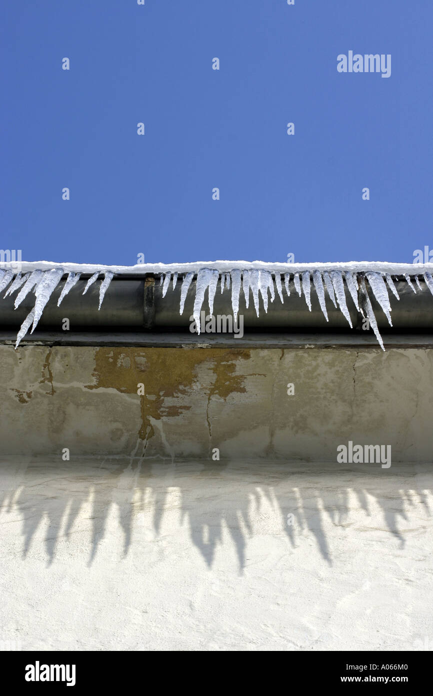 Sharp ice è formata in corrispondenza del bordo del tetto di un edificio Foto Stock