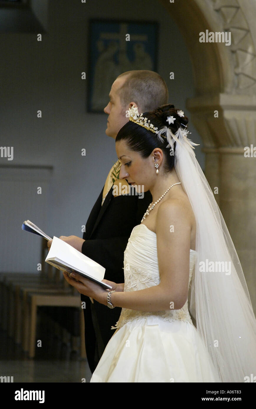 Sposa e lo Sposo cantando inni durante il regno unito la cerimonia nuziale Foto Stock