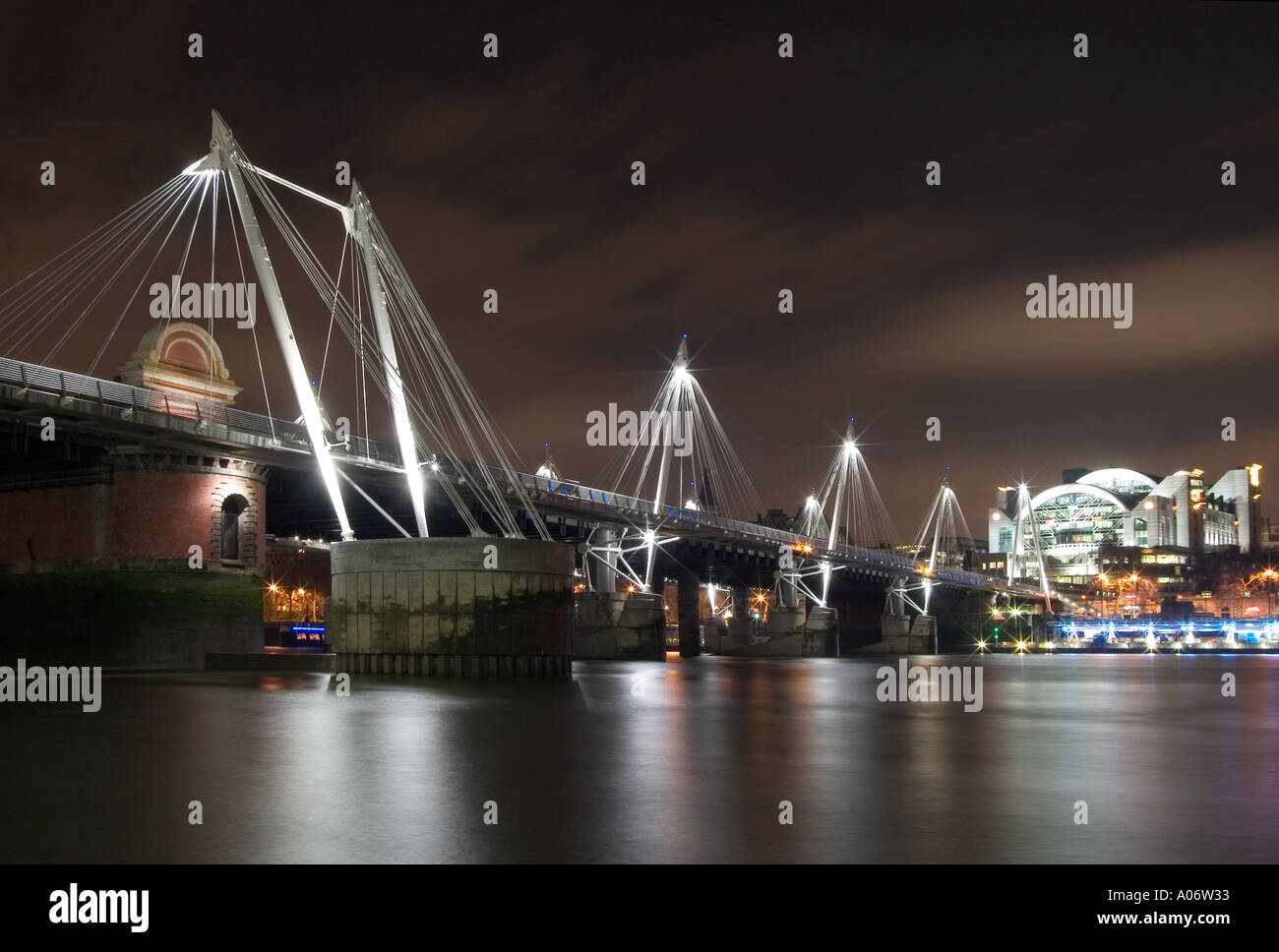 Hungerford Bridge e la stazione di Charing Cross di notte dal Tamigi foreshore. Londra, Inghilterra Foto Stock