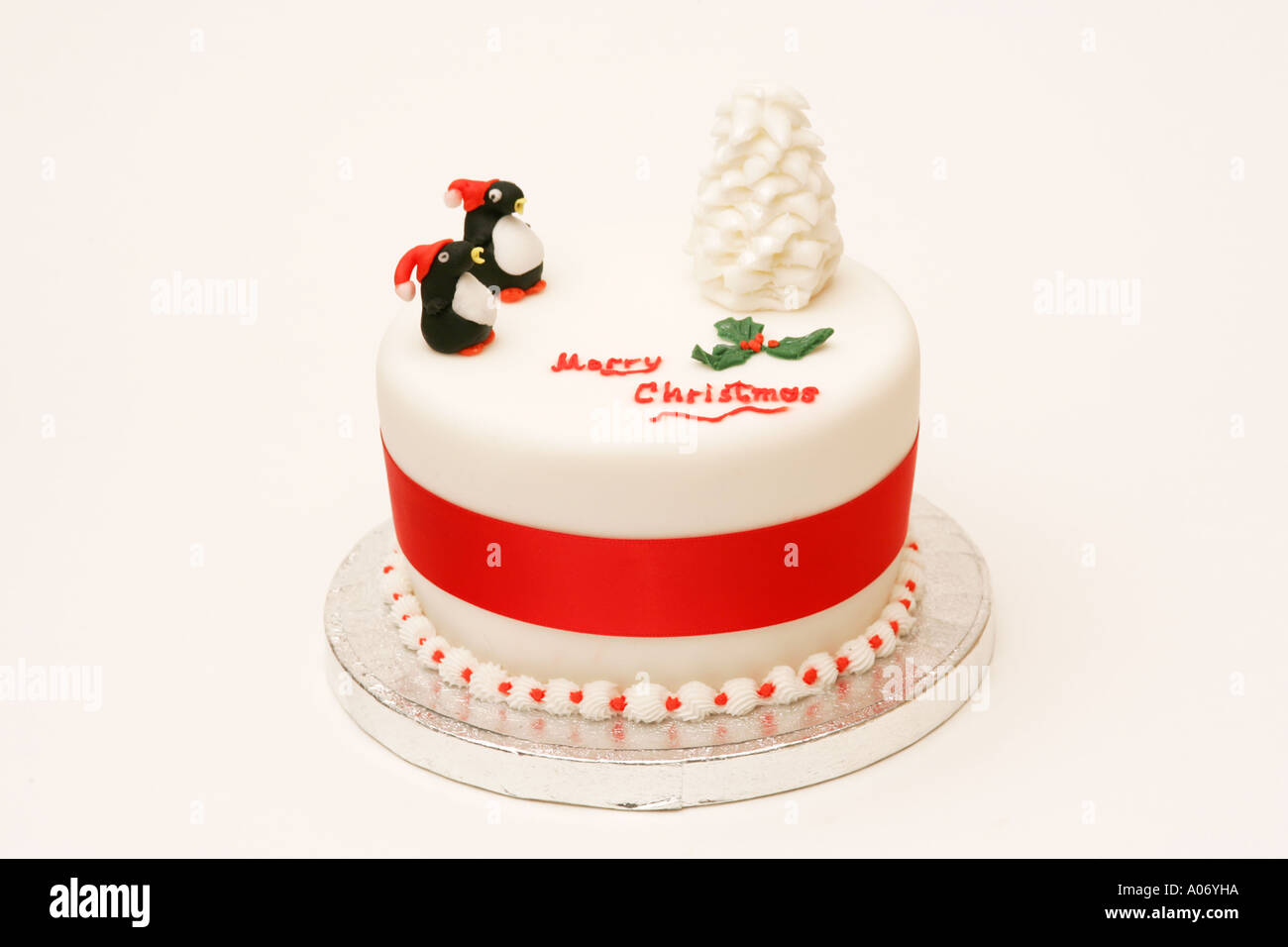 Tradizionale festa stagionali britannici torta di Natale con novità iced tree e le decorazioni dei pinguini e Buon Natale messaggio Foto Stock