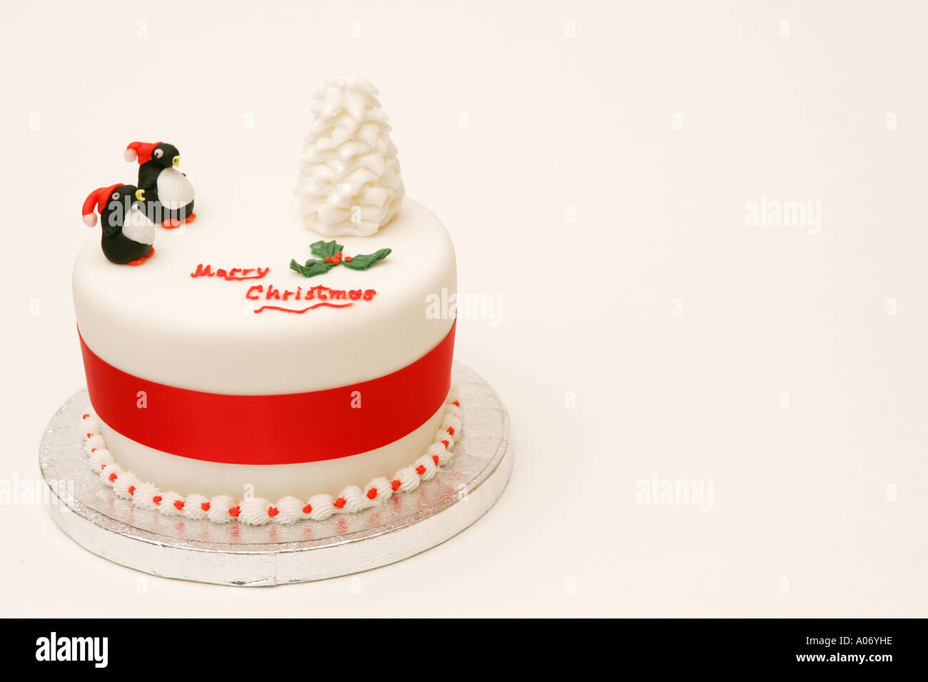 Offset tradizionale festa stagionali britannici torta di Natale con novità iced tree e decorazioni del pinguino Merry Chrristmas messaggio Foto Stock