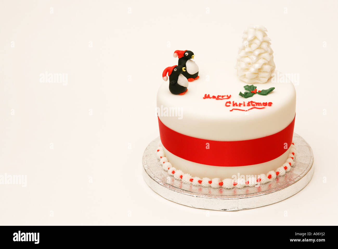 Offset tradizionale festa stagionali britannici torta di Natale con novità iced tree e decorazioni del pinguino Merry Chrristmas messaggio Foto Stock