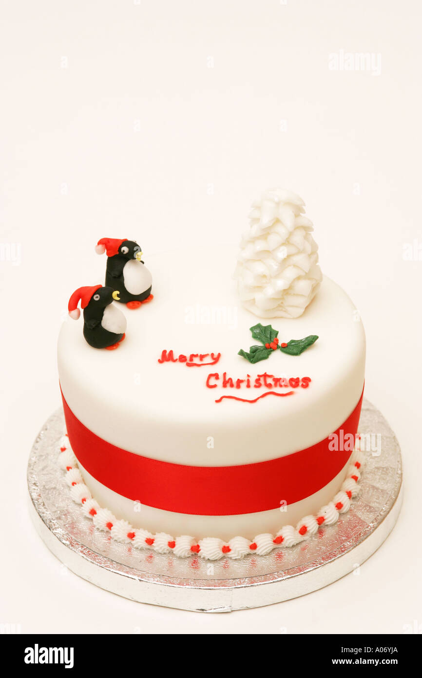 Tradizionale festa stagionali britannici torta di Natale con novità iced tree e decorazioni del pinguino Buon Natale messaggio Foto Stock