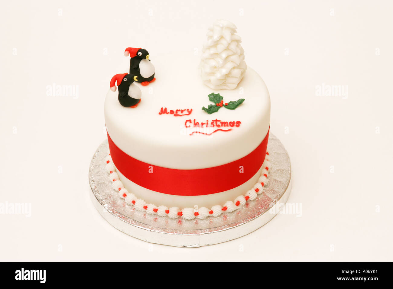 Offset tradizionale festa stagionali britannici torta di Natale con novità iced tree e decorazioni del pinguino Buon Natale messaggio Foto Stock