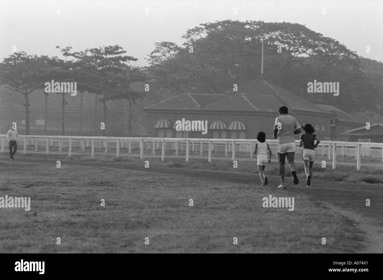 Padre e figli fare jogging a Mahalaxmi race course Bombay Mumbai India Foto Stock