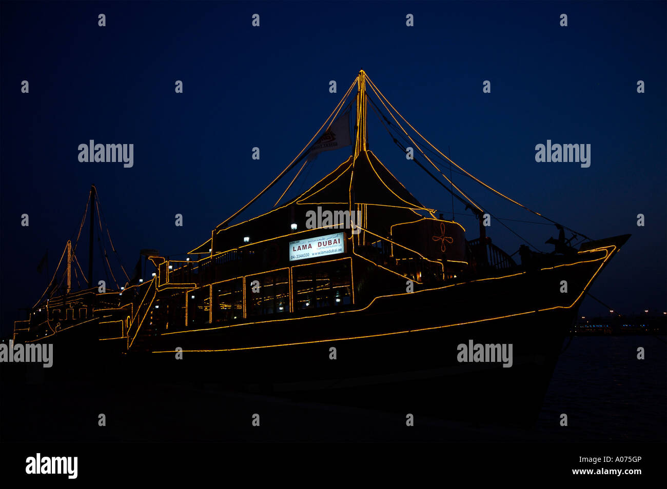 Lampadina accesa dhow Arabo al crepuscolo in attesa per i turisti lungo il Deira Creek Foto Stock