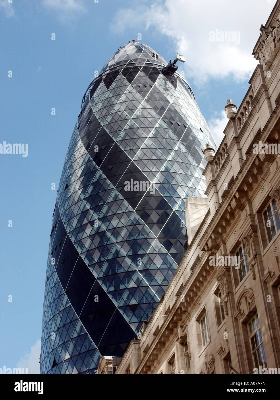 La vecchia e la nuova architettura in edifici per uffici con operai sul rivestimento del Gherkin lavora senza impalcatura Foto Stock