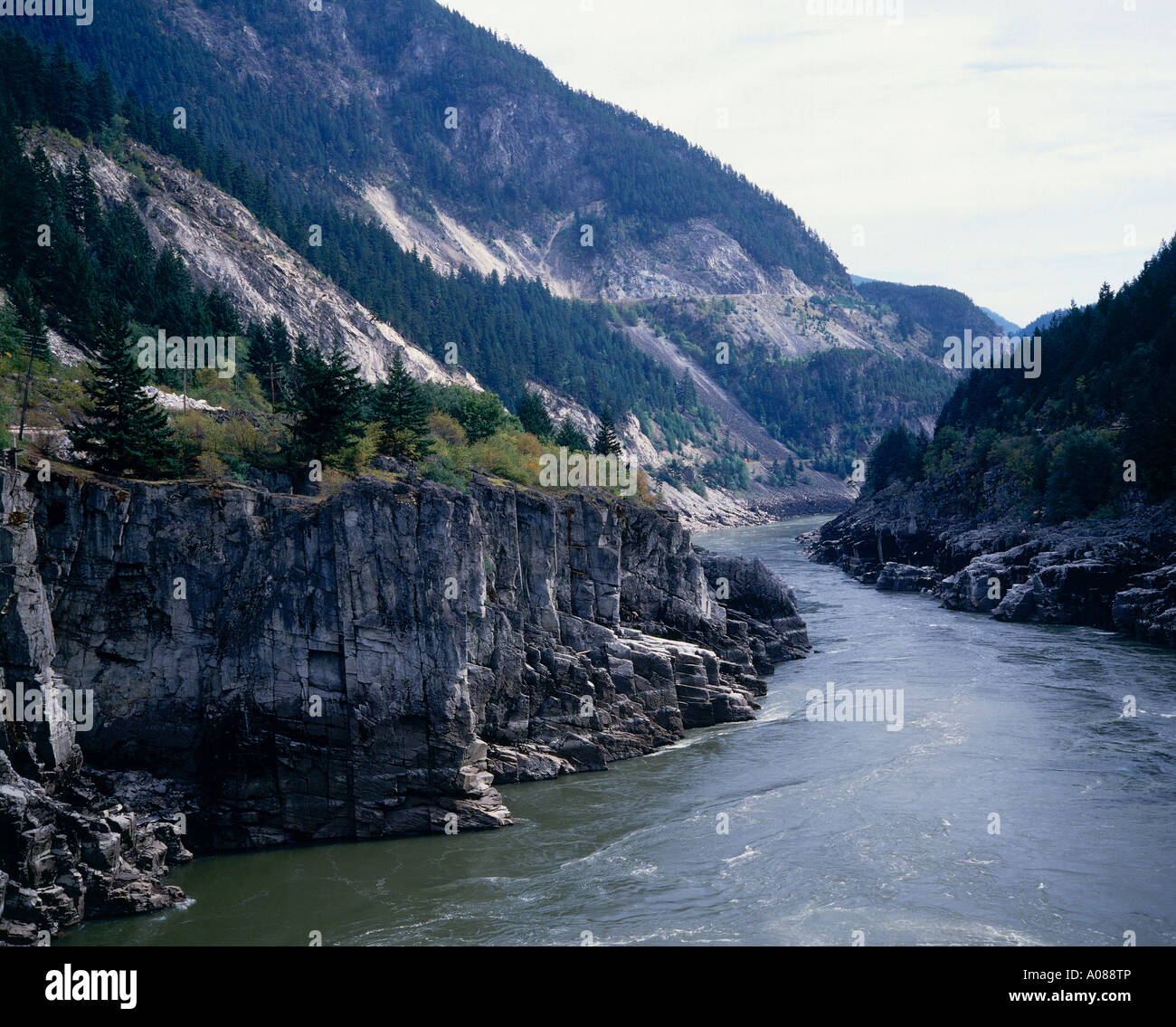 Il rapido rallentamento acque del fiume Fraser eseguire passato pareti rocciose a picco attraverso il canyon dello stesso nome Hell s Gate Foto Stock