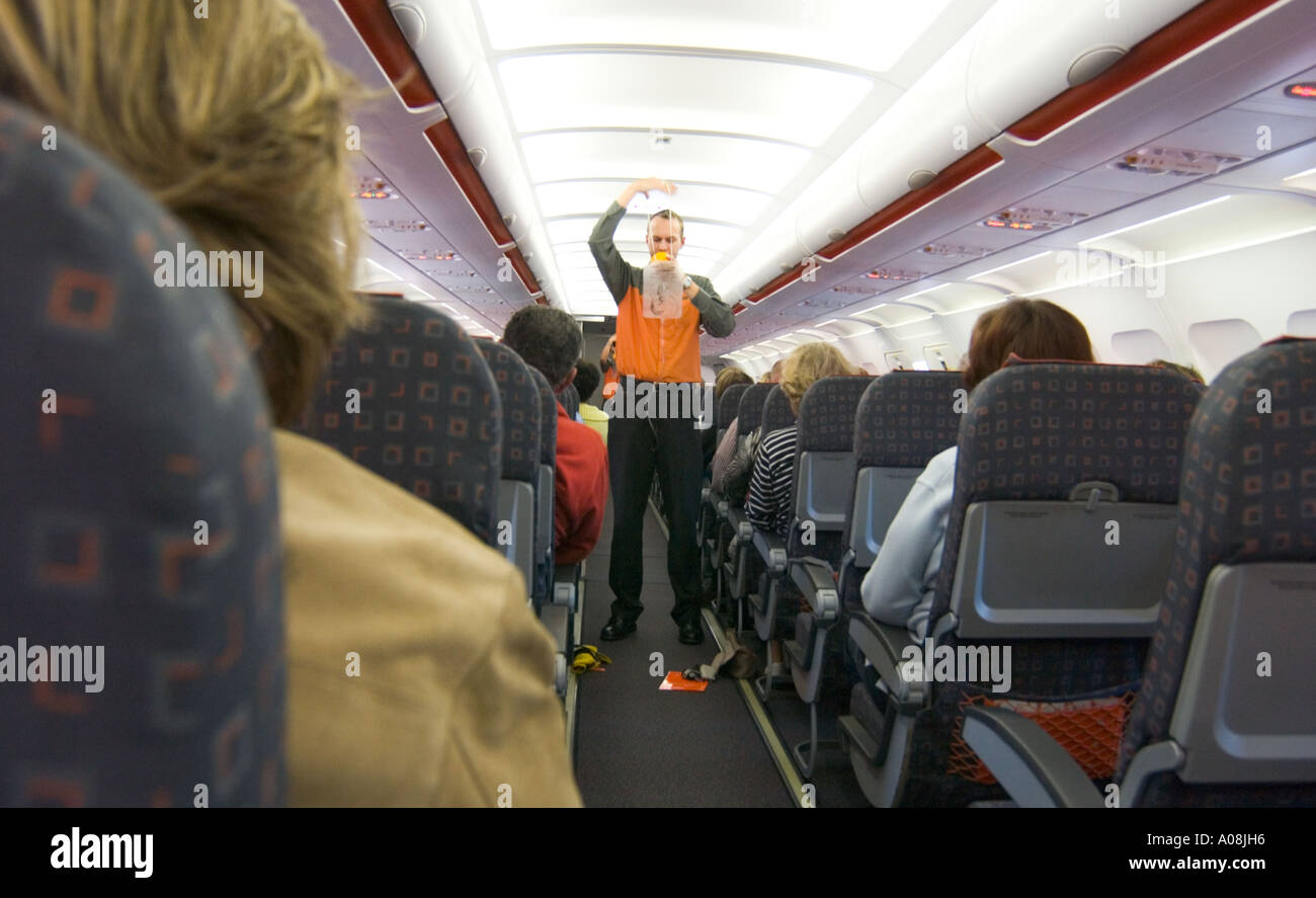 Steward dimostrando misure di emergenza su aereo Foto Stock